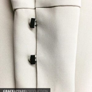 A close up of the buttons on a white jacket.