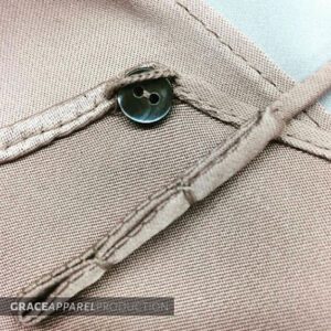 A button on the side of a tan jacket.
