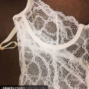 A white lace top with a hanger hanging from it.