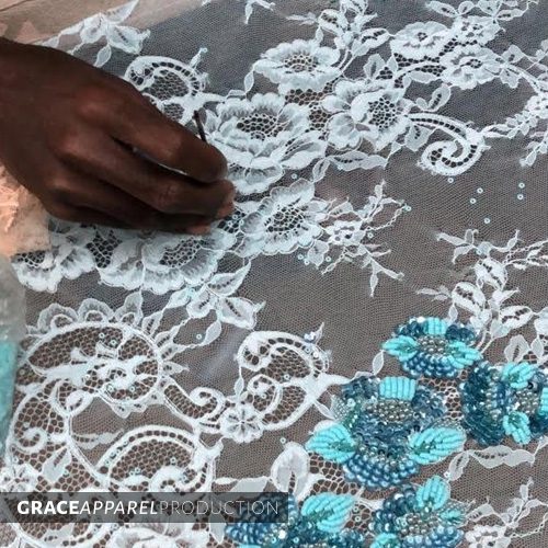 A person is working on a lace design.