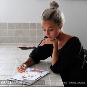 A woman sitting at the table painting with her brush
