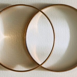 Two gold rings are shown on a white surface.