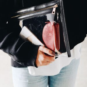 A person holding a wallet and purse in their hands.