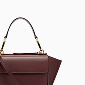 A close up of the handle on a burgundy bag