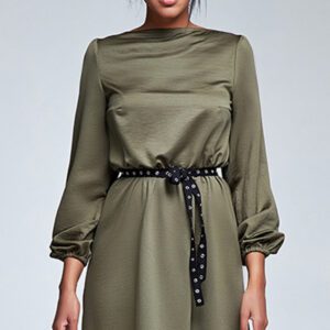 A woman wearing a dress with long sleeves and a black belt.